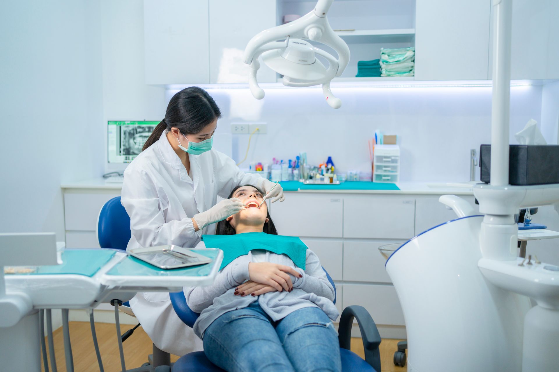 Dentist wearing face mask, providing dental service in clinic.