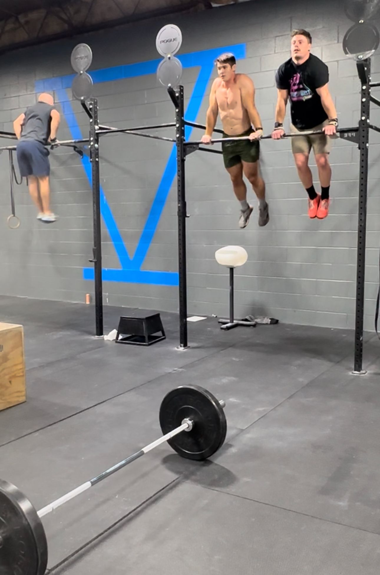 A group of men are doing pull ups in a gym.