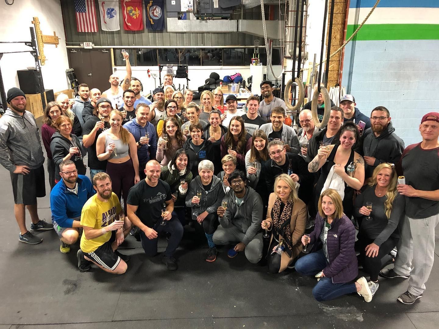 A large group of people are posing for a picture in a gym.