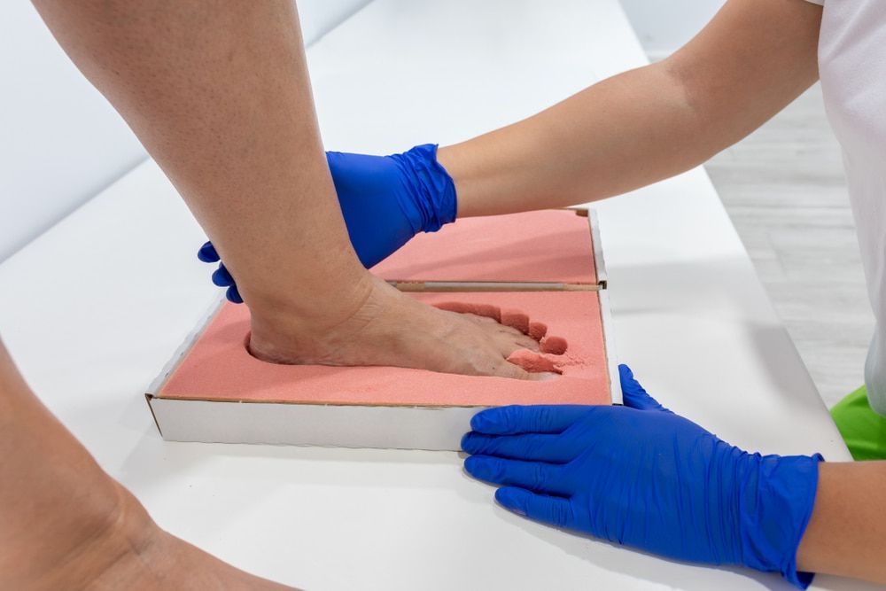 A Person Is Getting Their Foot Measured by A Doctor — Betta Foot Clinic in Kuraby, QLD