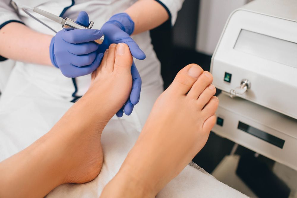 A Woman Is Getting Her Toenails Trimmed by A Podiatrist — Betta Foot Clinic in Kuraby, QLD