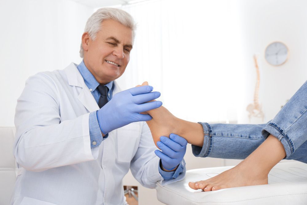 A Doctor Is Examining a Patient's Foot in A Hospital — Betta Foot Clinic in Calamvale, QLD