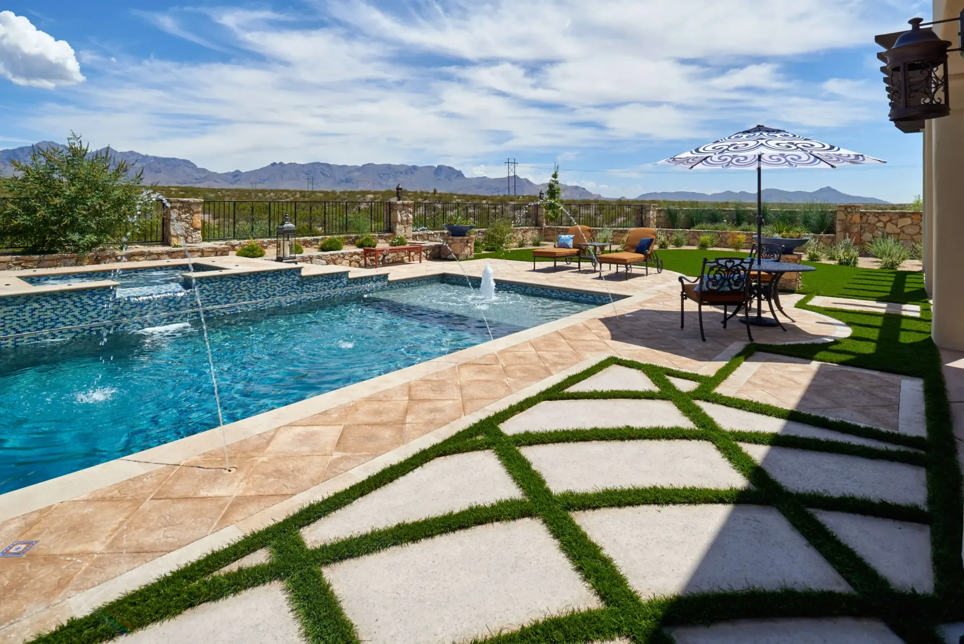 Poolside patio with pool, umbrella, patio furniture, and mountain view.