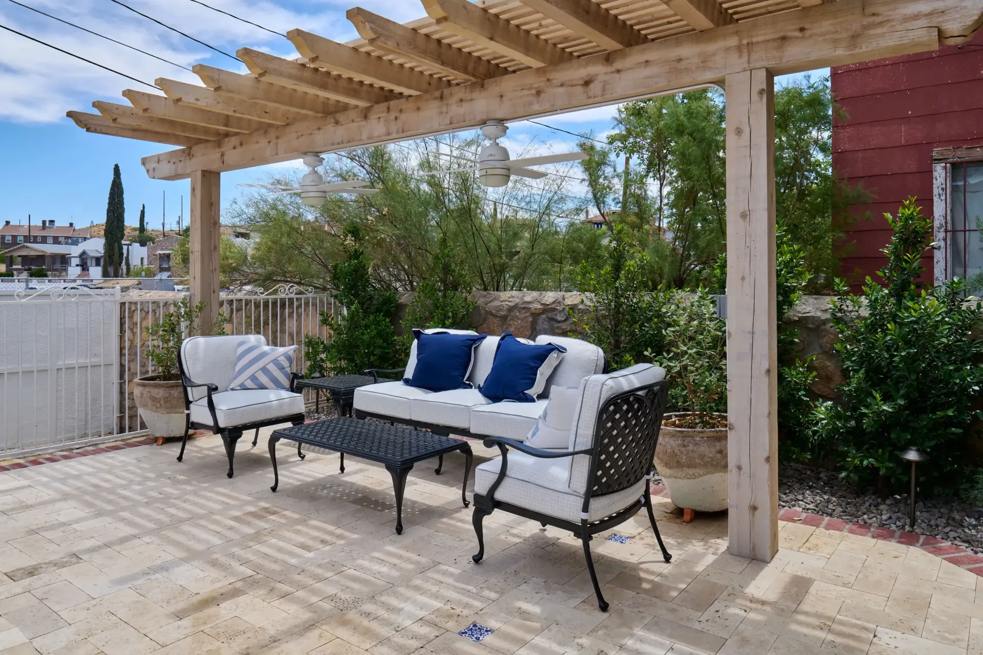 Patio with seating under a wooden pergola, string lights above.
