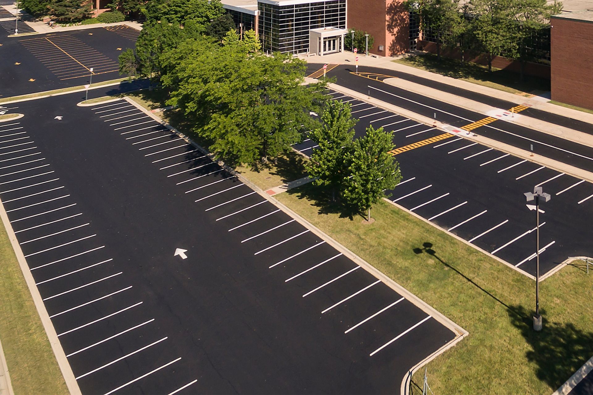 Aerial view of a newly paved parking lot with white parking space lines.