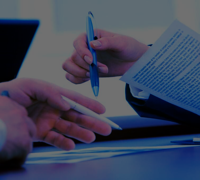 Una persona sostiene un bolígrafo sobre un trozo de papel.