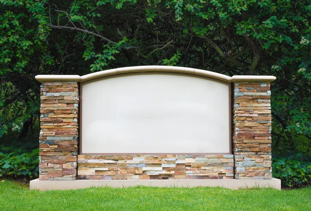A Large Stone Sign Is Sitting in The Middle of A Lush Green Field — Nick Locke Monuments in Macksville, NSW