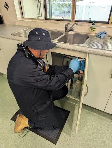 Worker Injecting a Chemical Into the Ground with A Hose — Total Pest and Carpet Cleaning in Yeppoon, QLD