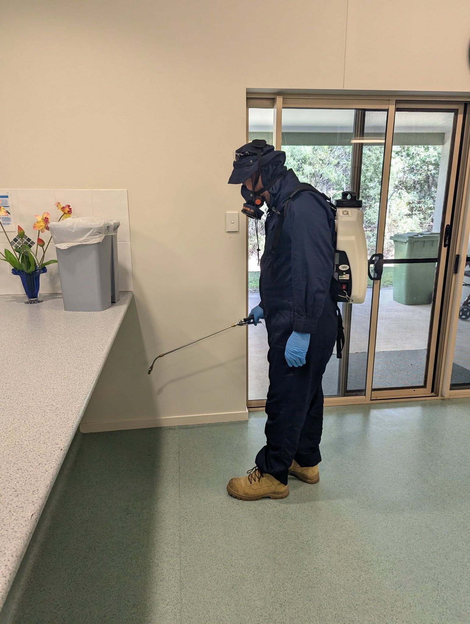 A Person Using a Pest Control Tool to Treat the Floor — Total Pest and Carpet Cleaning in Yeppoon, QLD