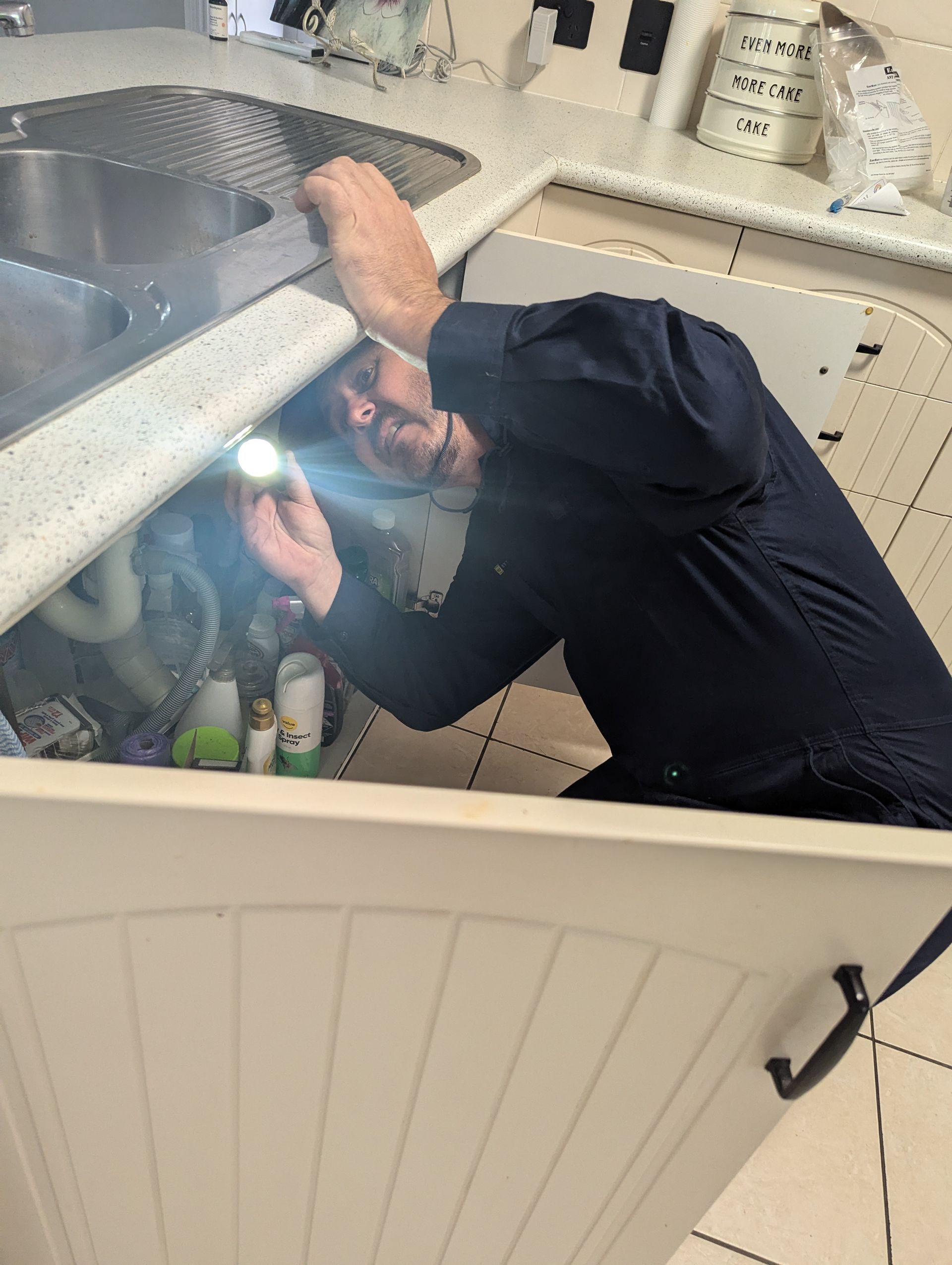 A Man is Cleaning a Wall With a Vacuum Cleaner — Total Pest and Carpet Cleaning in Kinka Beach, QLD