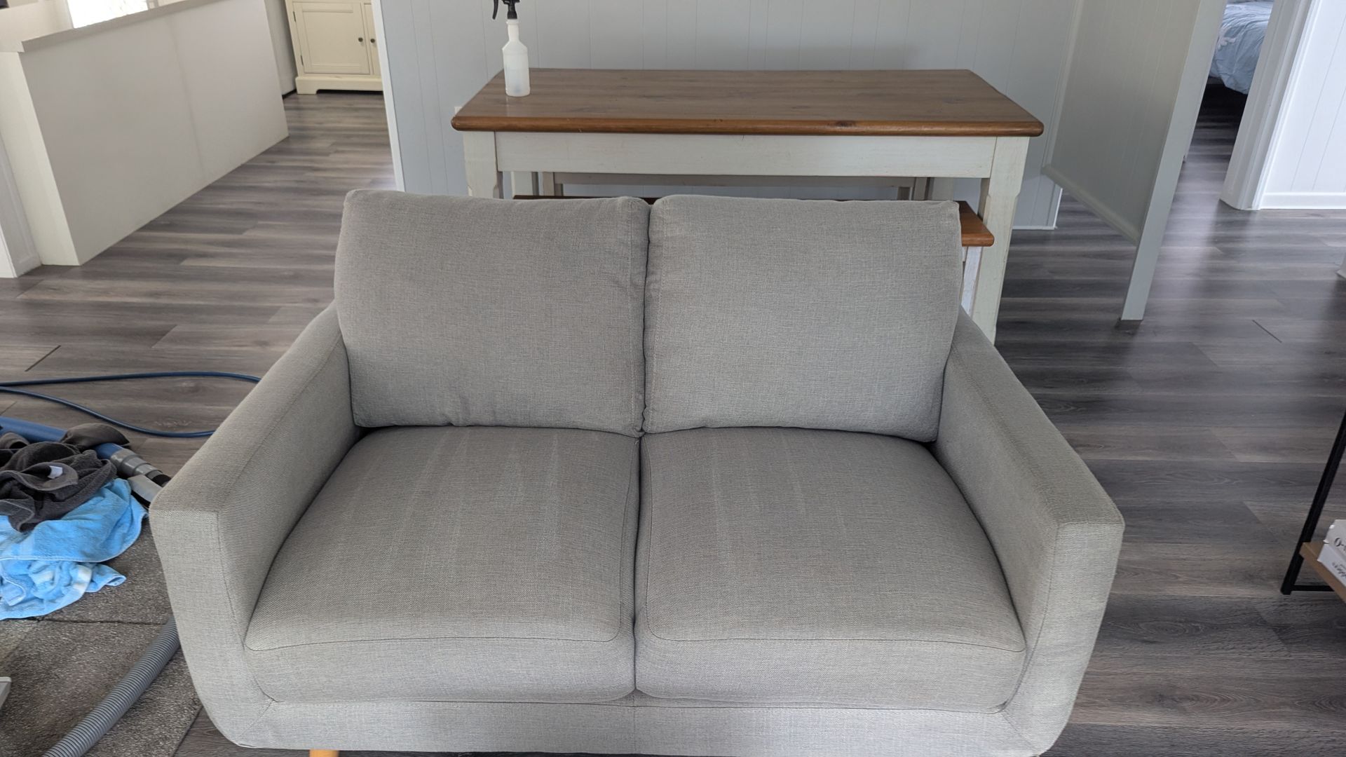 A Blue Vacuum Cleaner is Being Used to Clean a Couch — Total Pest and Carpet Cleaning in Emu Park, QLD