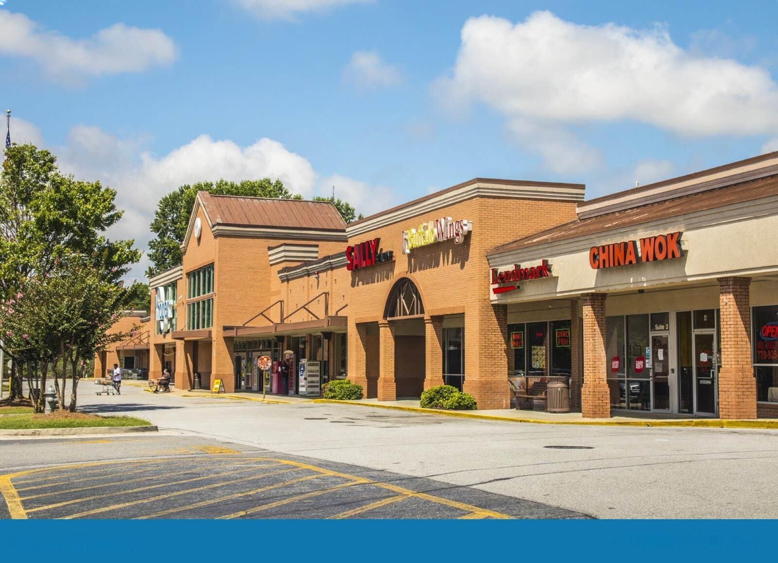 Hands of two people, placing wedding rings down near a divorce decree on a dark wooden table.