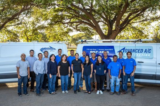 A group of people are posing for a picture in front of a van.