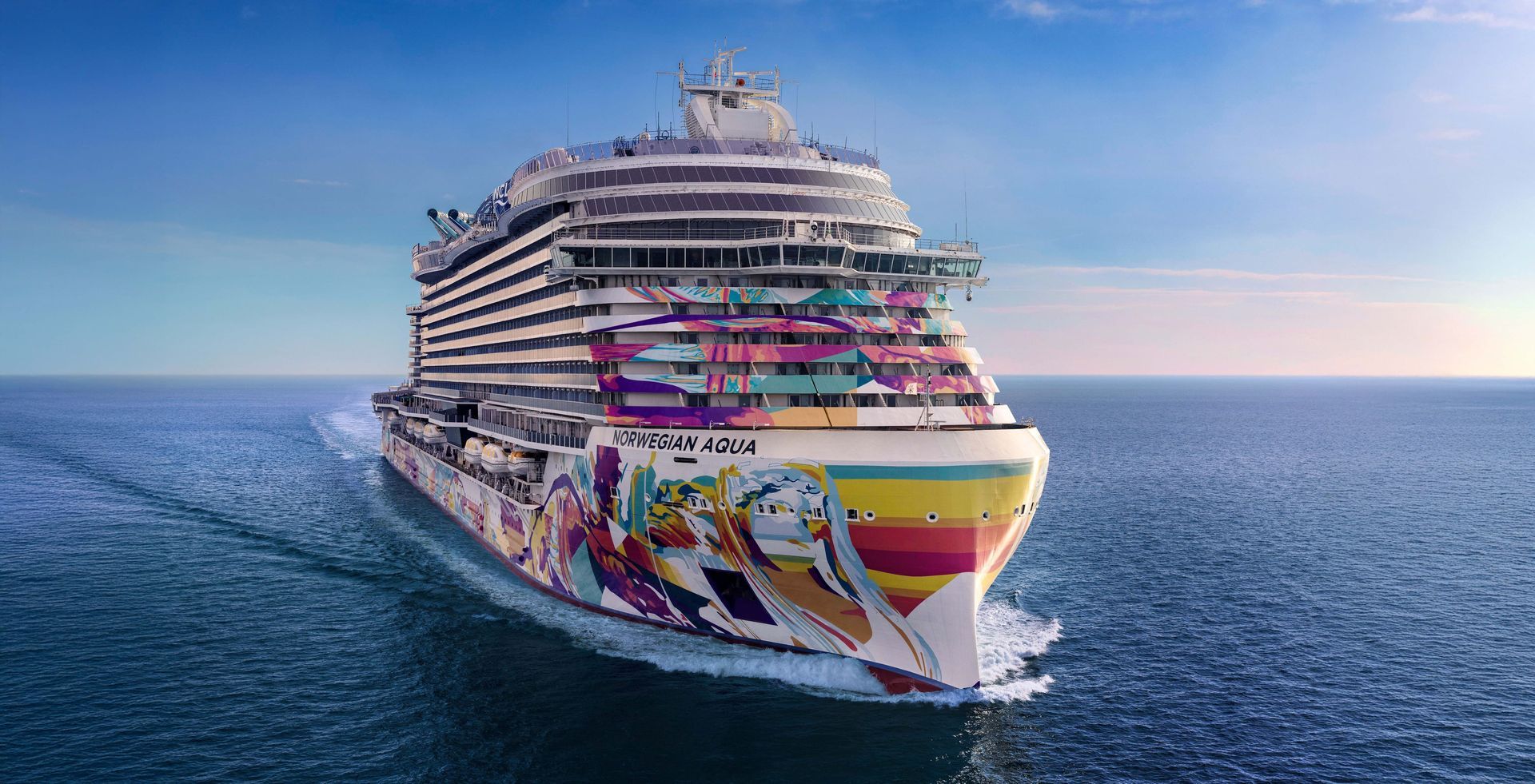 A colorful cruise ship sailing on a blue ocean under a sunny sky.
