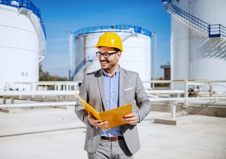 engineer walking by storage tanks