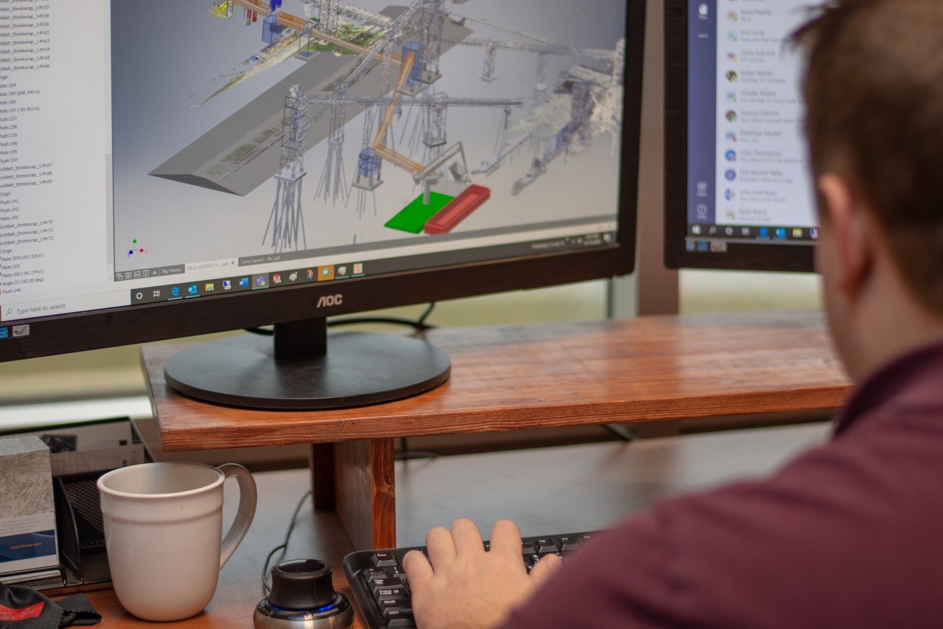 A man is sitting at a desk looking at a computer screen.