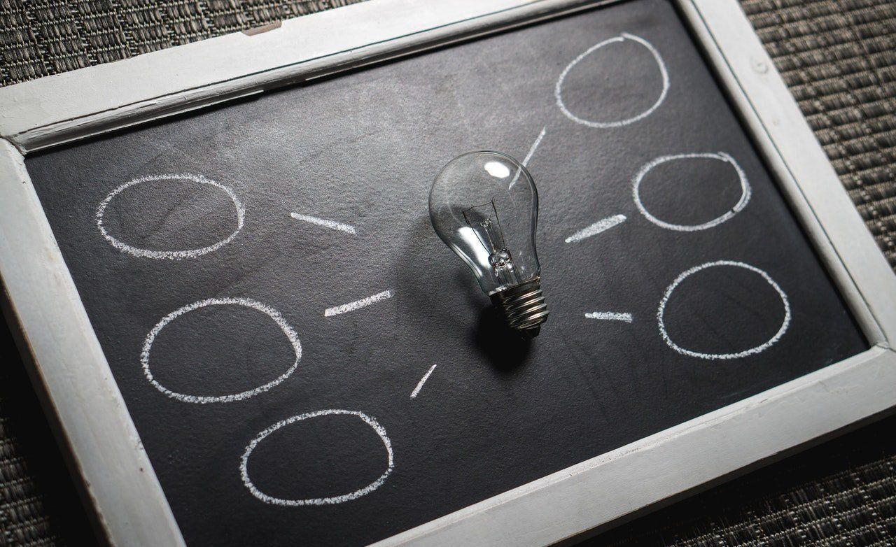 A light bulb is sitting on top of a blackboard with circles drawn on it.