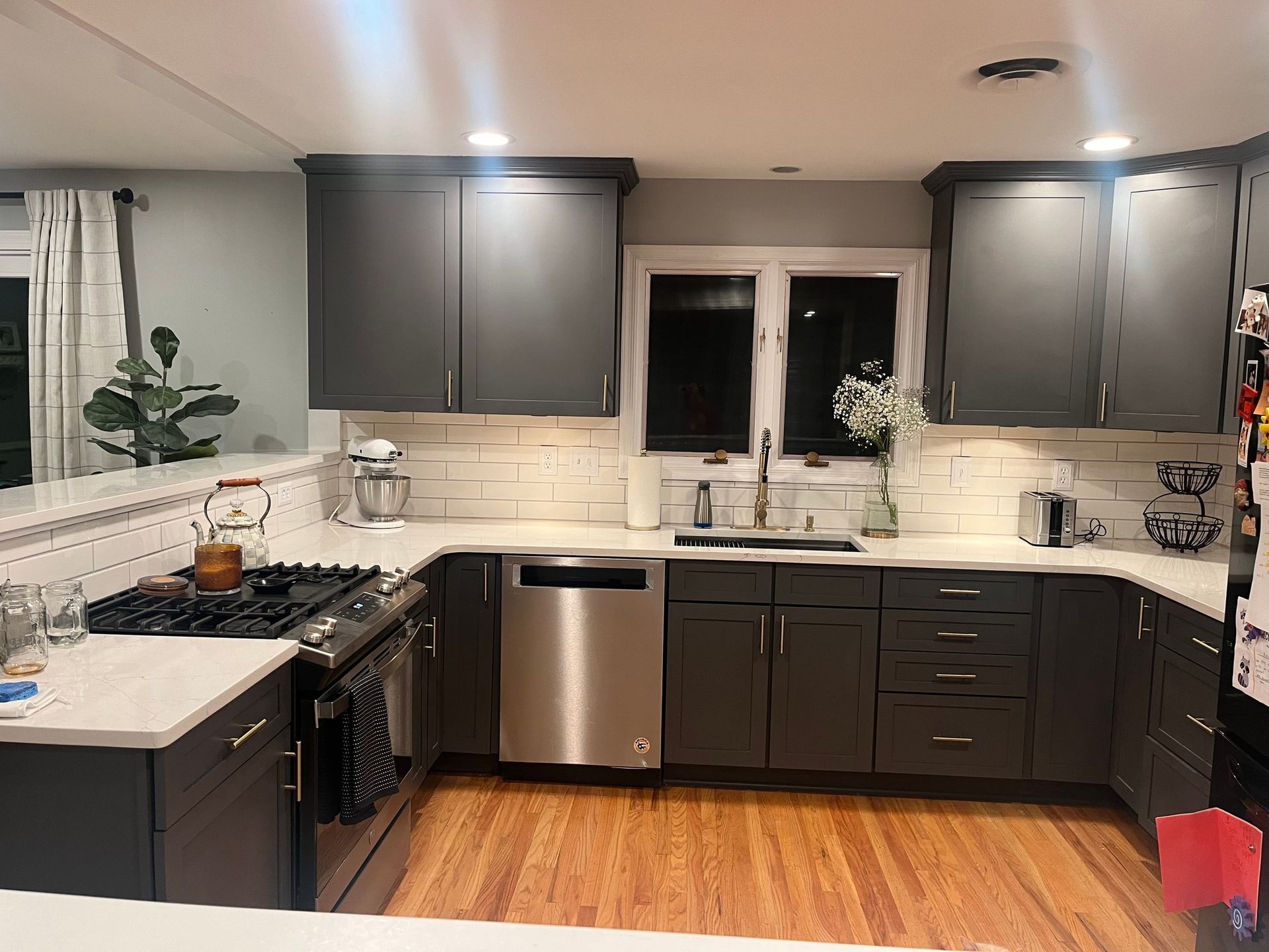 A kitchen with gray cabinets and stainless steel appliances