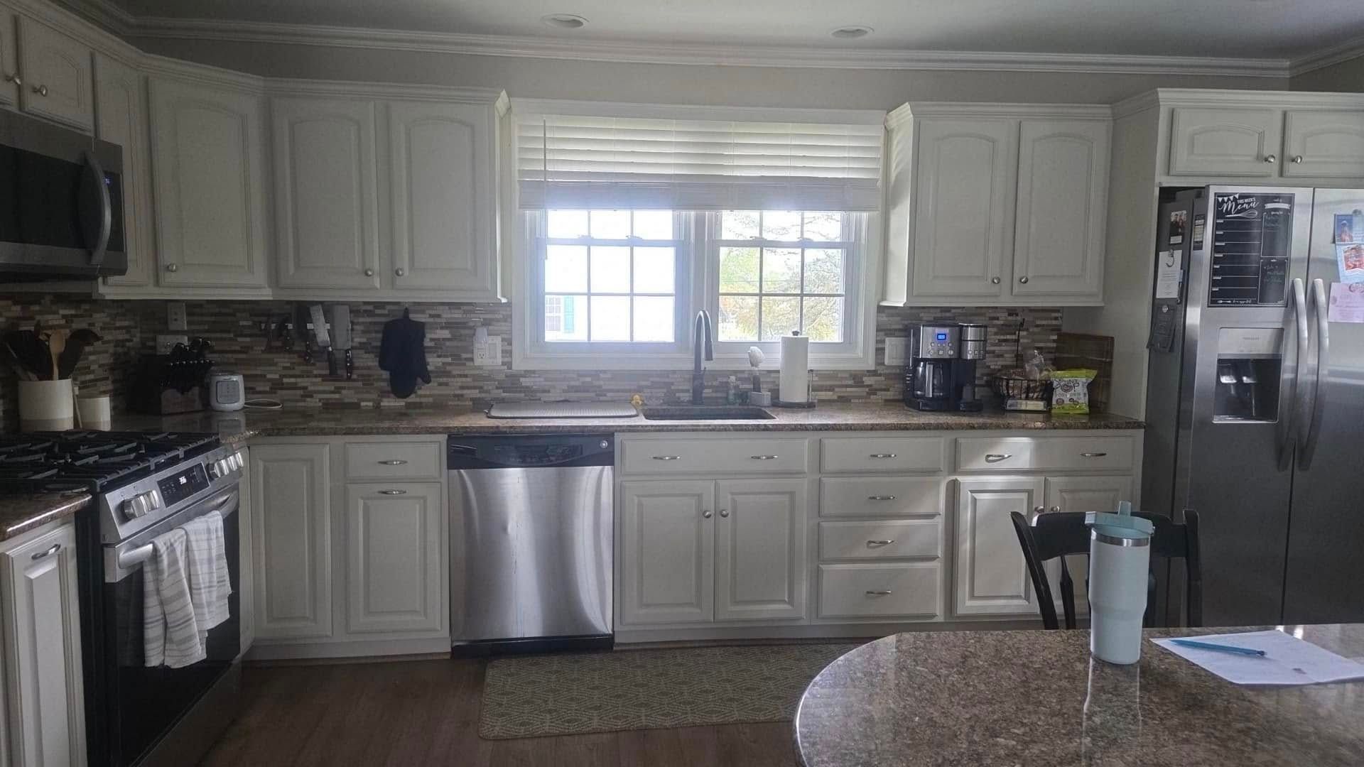 A kitchen with white cabinets and stainless steel appliances.