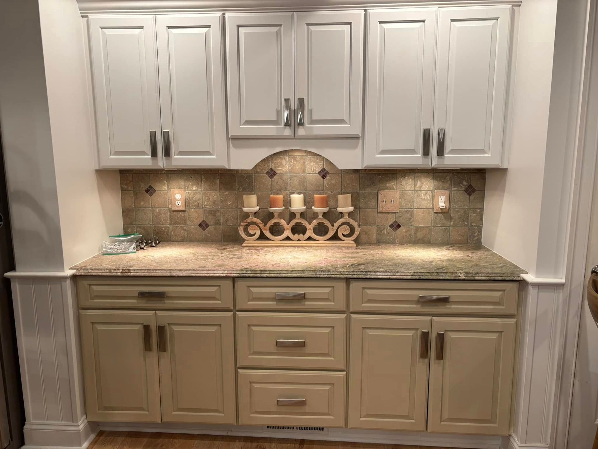 A kitchen with white cabinets and granite counter tops.
