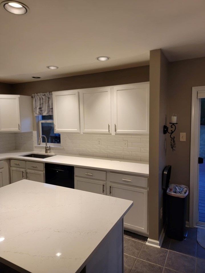 A kitchen with white cabinets and a large island