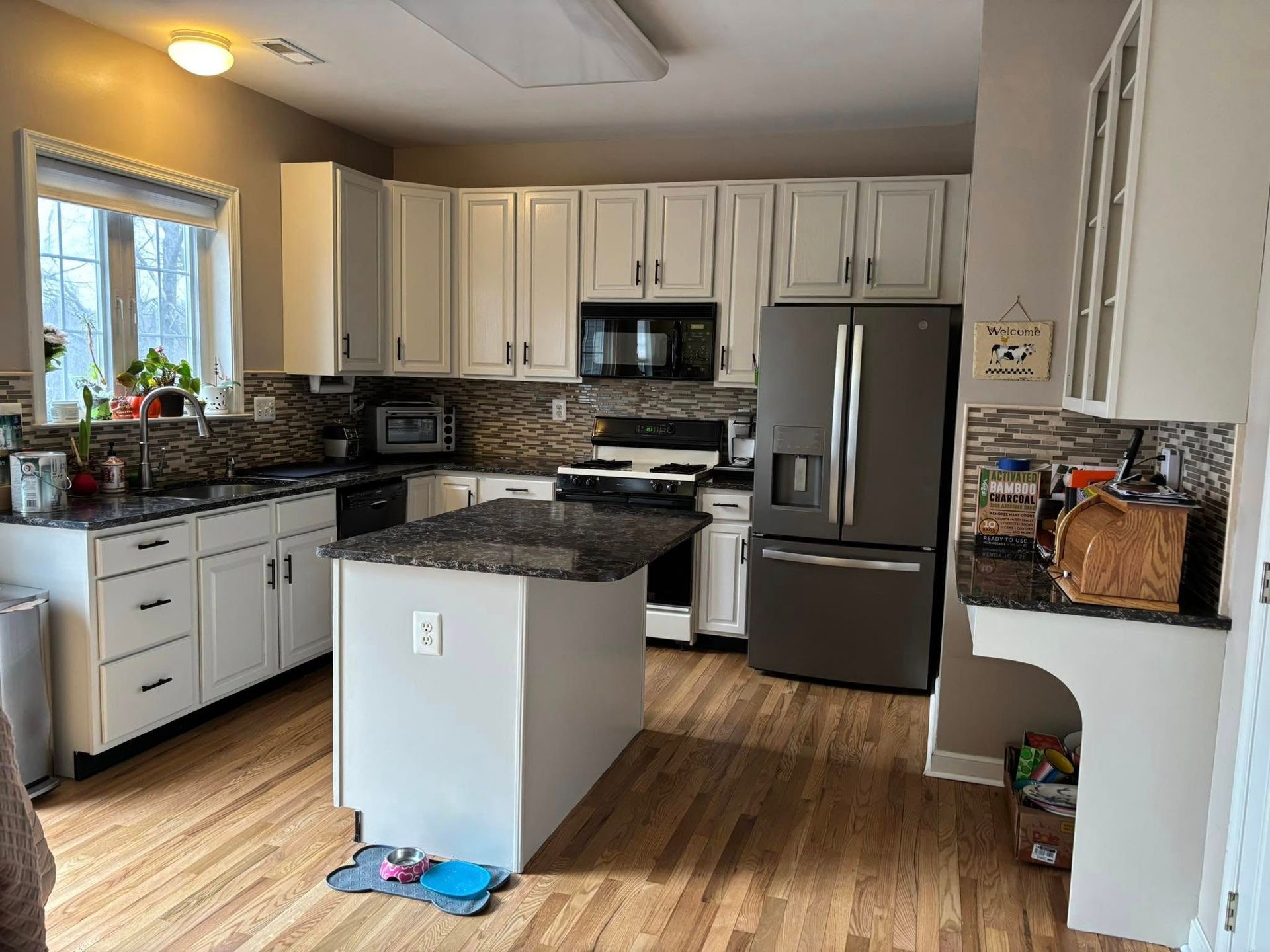 A kitchen with white cabinets and granite counter tops