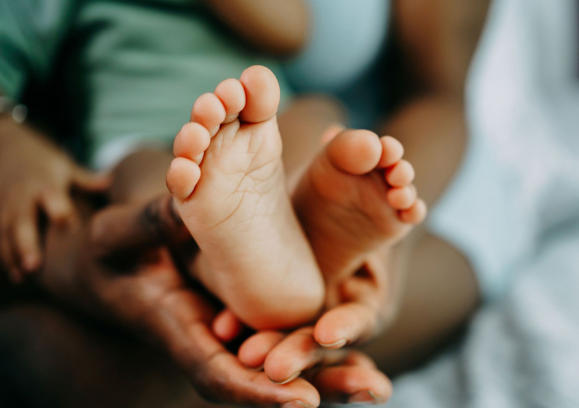 A person is holding a baby 's feet in their hands.