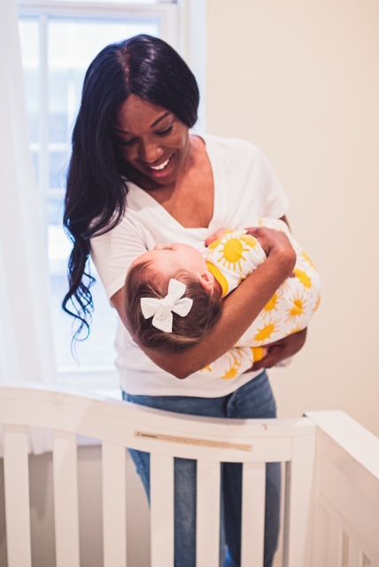 An elderly woman is holding a crying baby in her arms.