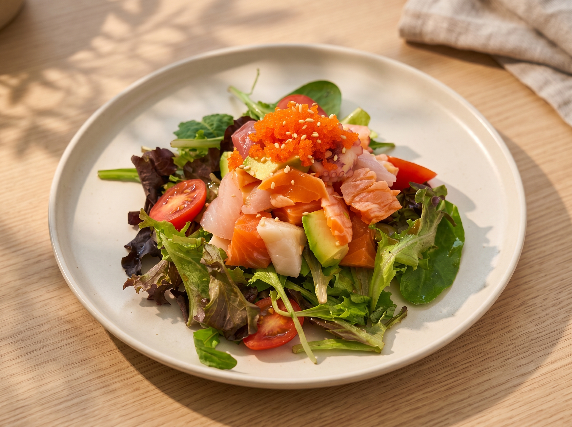 Fresh salad with salmon, avocado, and orange roe on a white plate