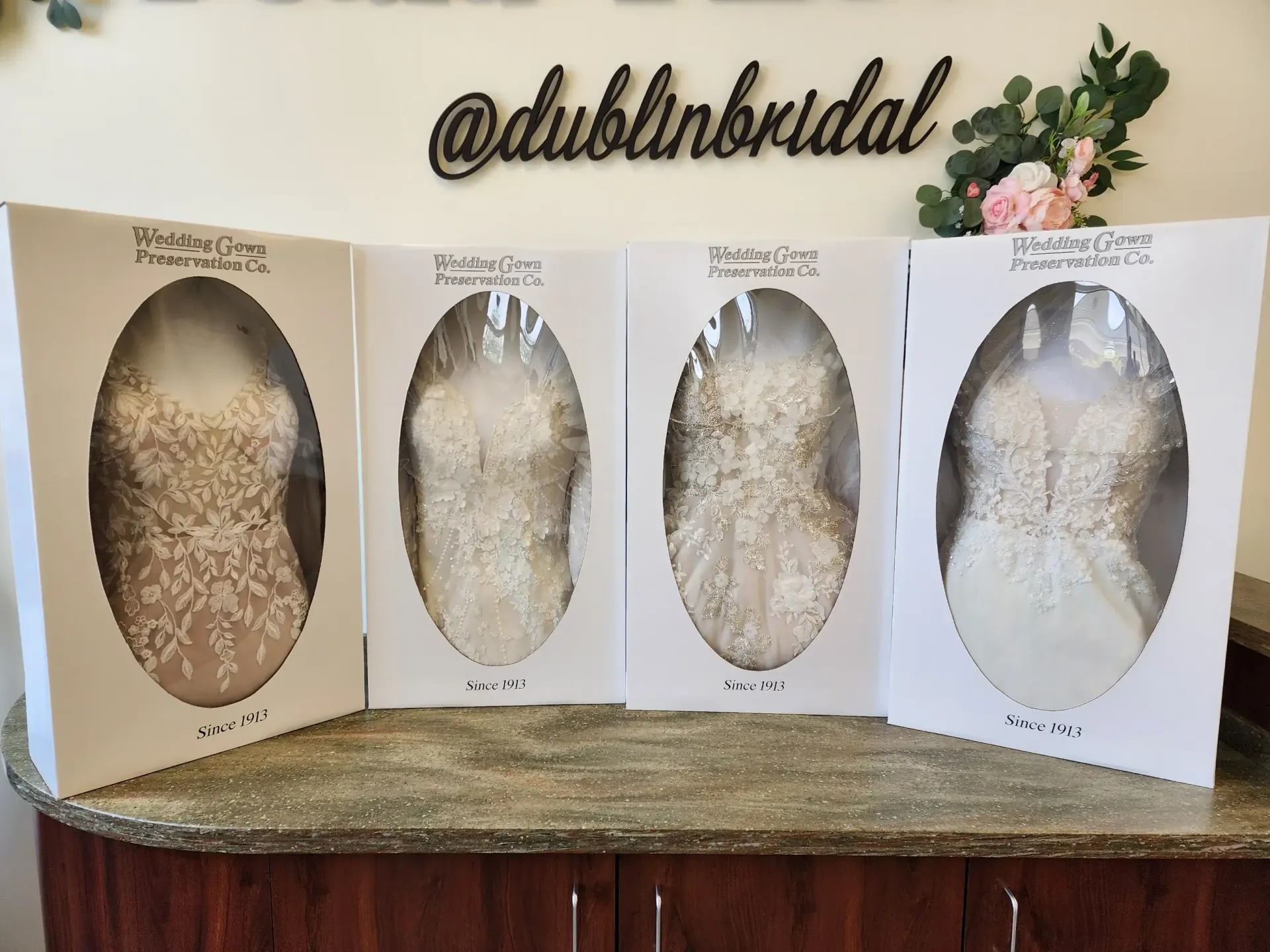 Four wedding dresses displayed in boxes at Dublin Bridal.