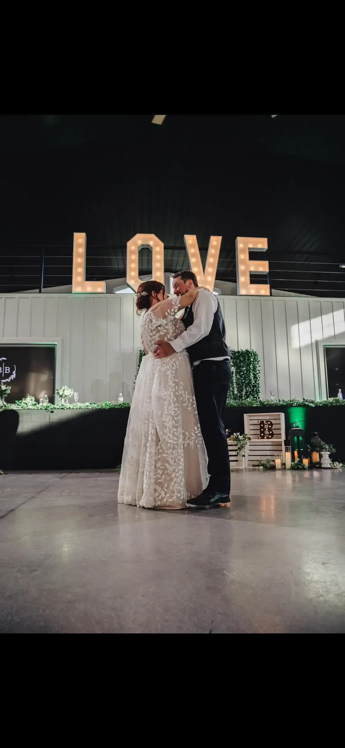Bride and groom embrace on a dance floor, 