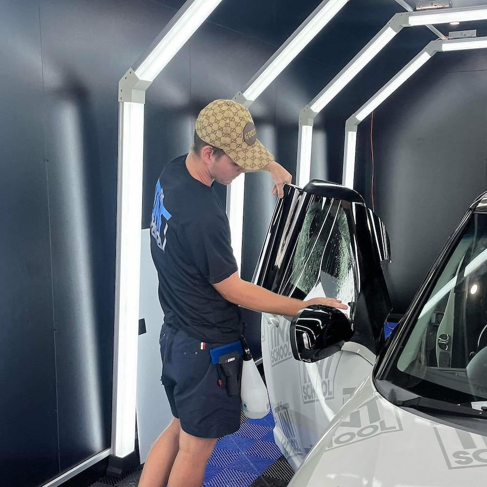 A Man Wearing a Hat is Working on a Car — TB Detailing in Miles End, QLD