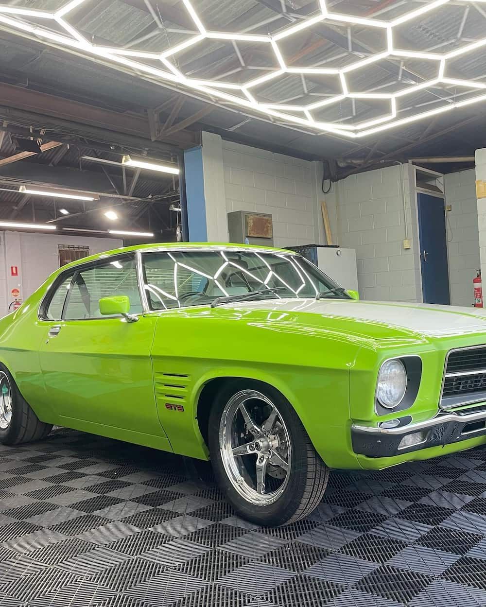 A Green and White Car is Parked in a Garage — TB Detailing in Miles End, QLD