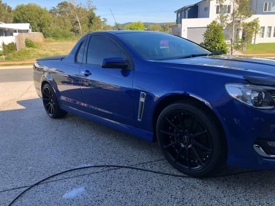 A Blue Car is Parked in a Driveway Next to a Hose — TB Detailing in Miles End, QLD