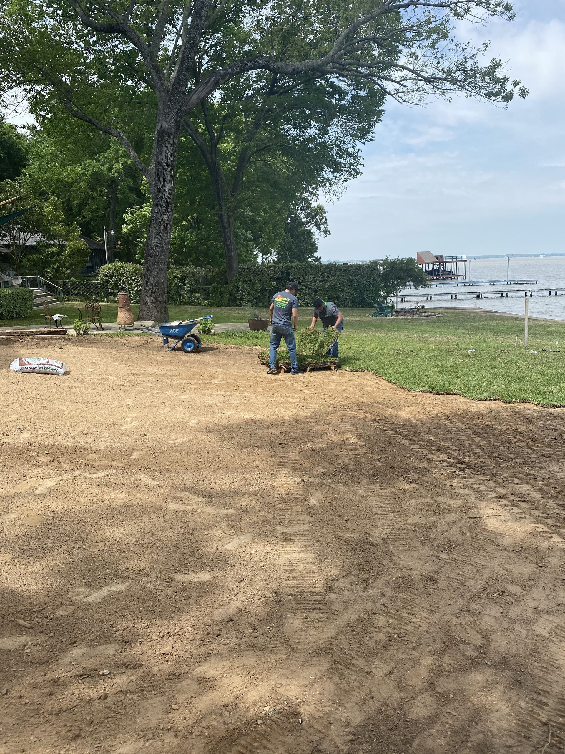 A man is standing in the middle of a dirt field.