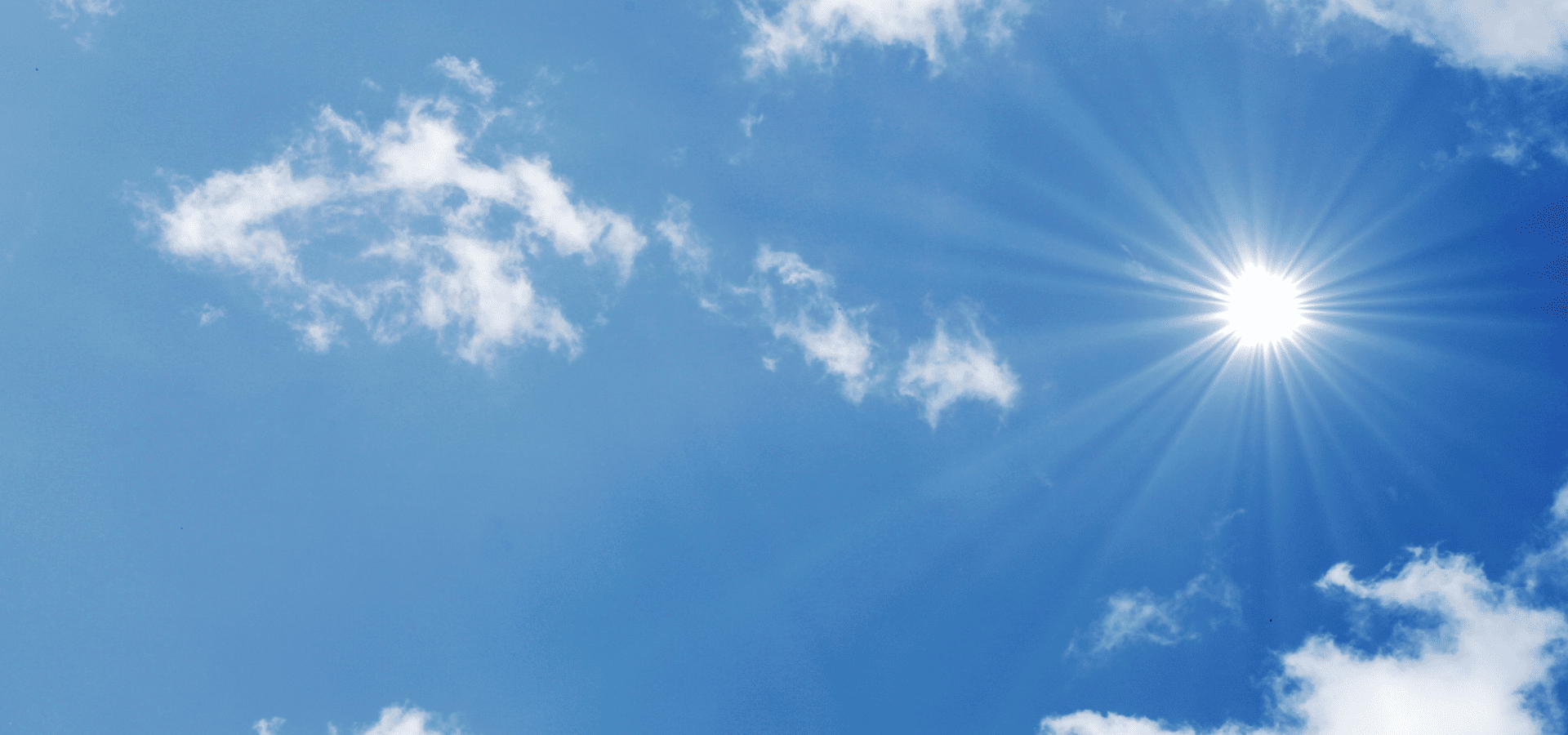Sun shining brightly in the sky with clouds around