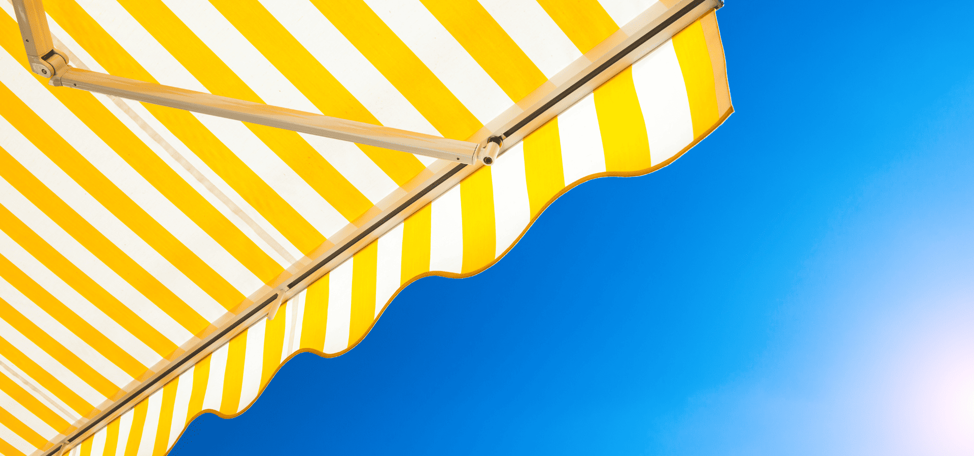 Yellow striped UV-resistant fabric awning in the sun