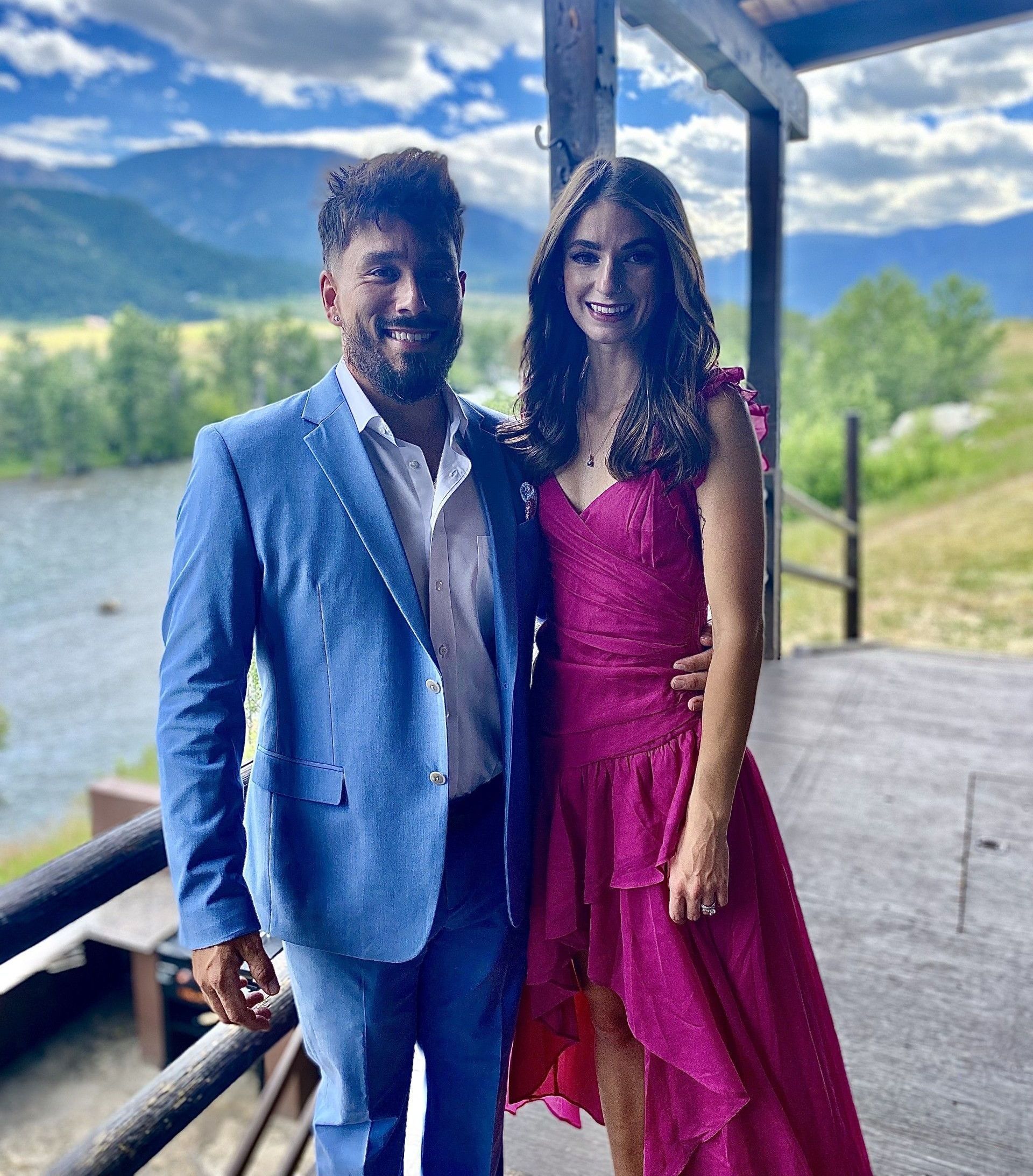 A man in a blue suit and a woman in a pink dress are posing for a picture.