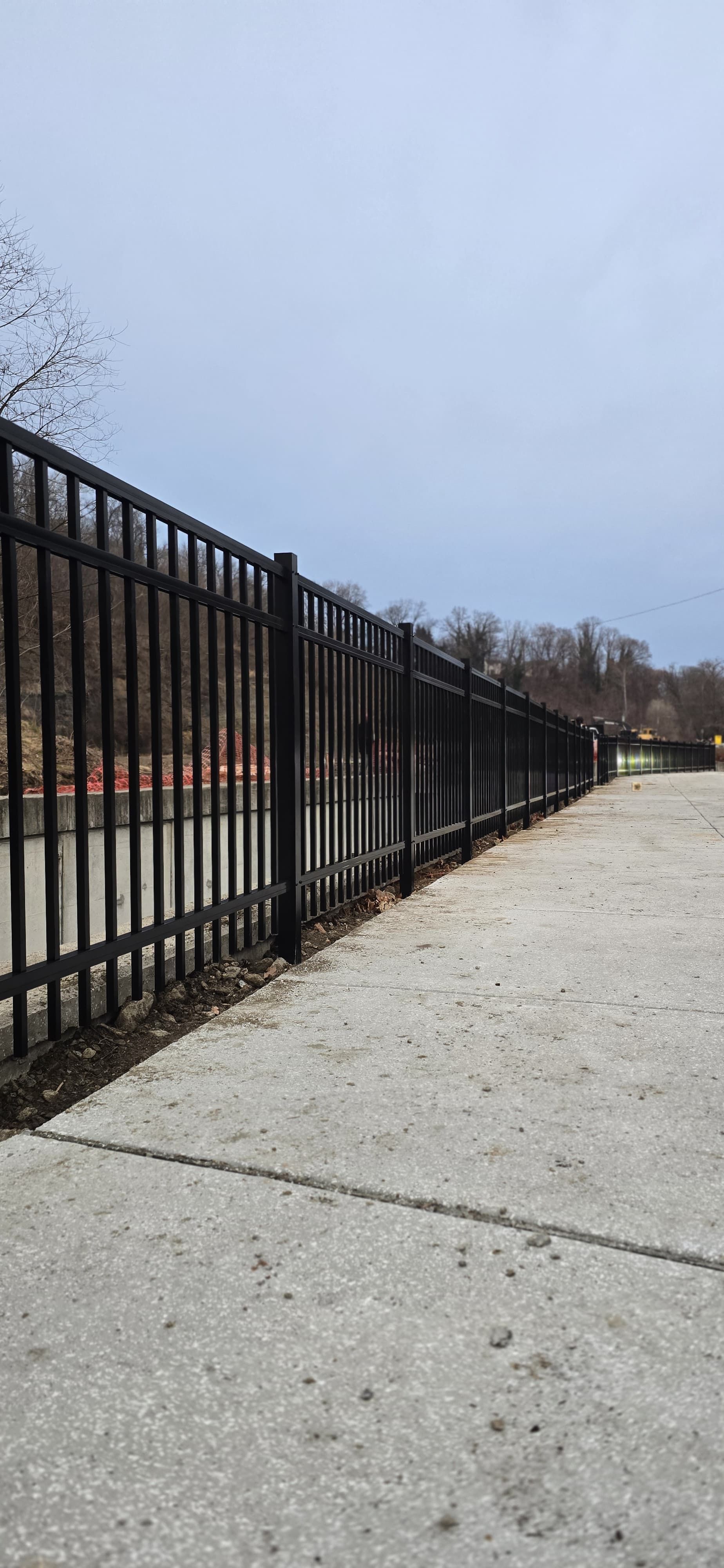 White building with a red and white striped columns on the porch. Black fence surrounds the porch.
