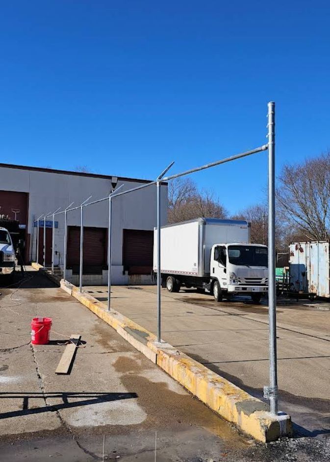 Loading dock with metal safety rails; white truck parked. Clear, sunny day.