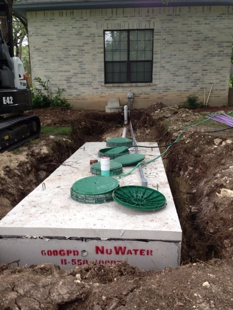 A septic tank is being installed in the backyard of a house.