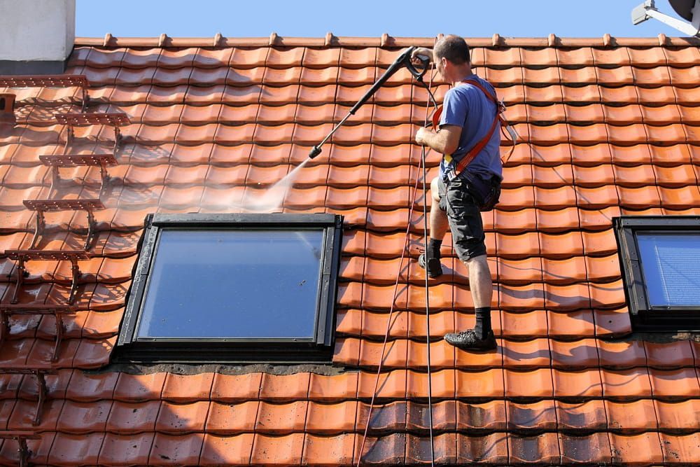 Man Cleaning Roof with High-Pressure Washer — Cleaning & Security in Townsville QLD