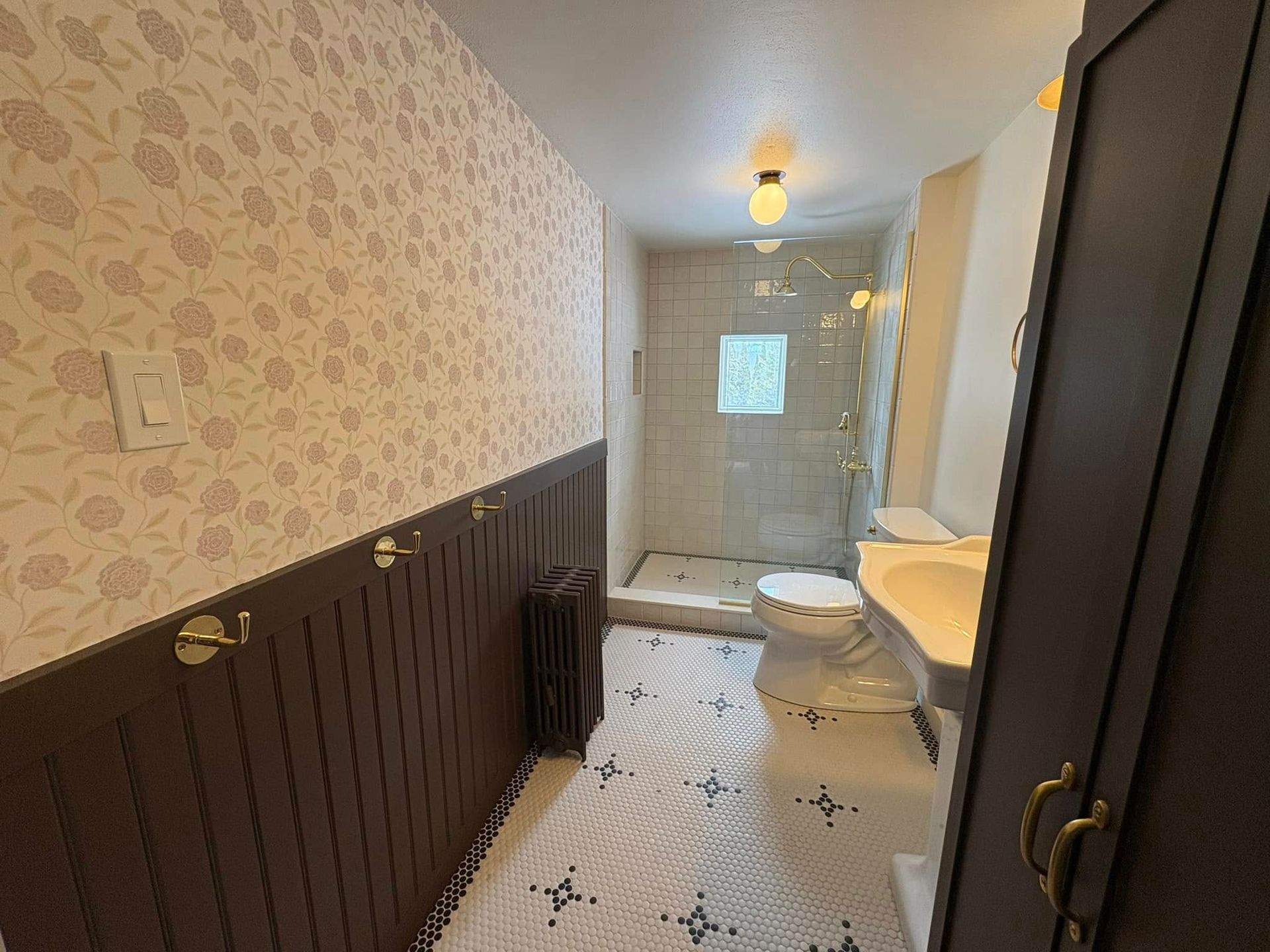 A bathroom with a toilet , sink , and shower.