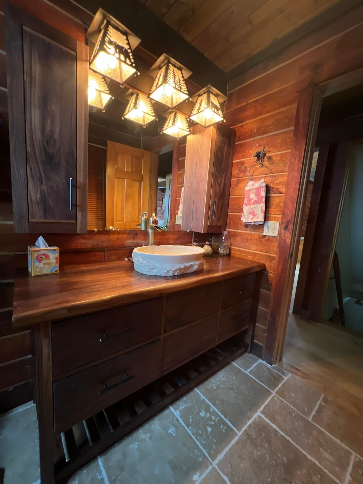 A bathroom in a log cabin with a sink and a mirror.