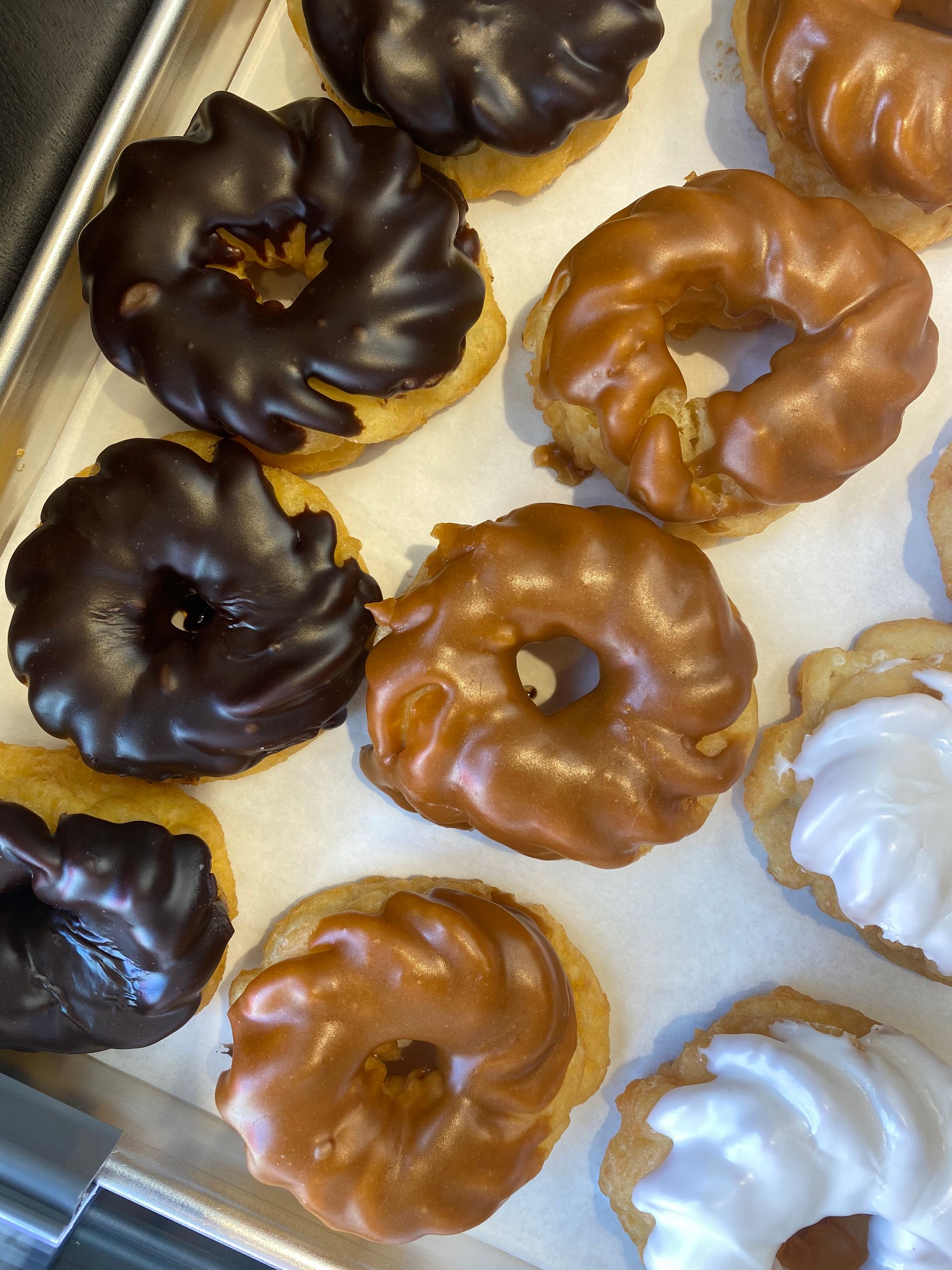 A tray of donuts with chocolate and caramel icing