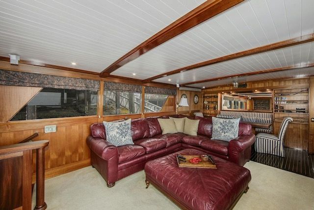 Living room on a boat with a red leather sectional, ottoman, and wooden accents.