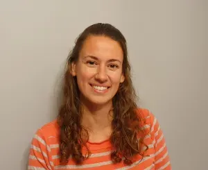 A woman in a striped shirt is smiling for the camera.