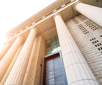 Looking up at a building with columns and a door.