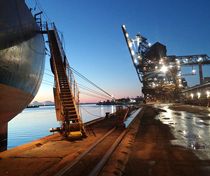 A large ship is docked in a harbor at night