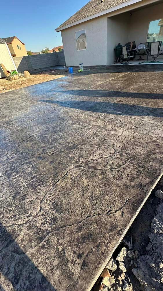 A concrete driveway is being installed in front of a house.